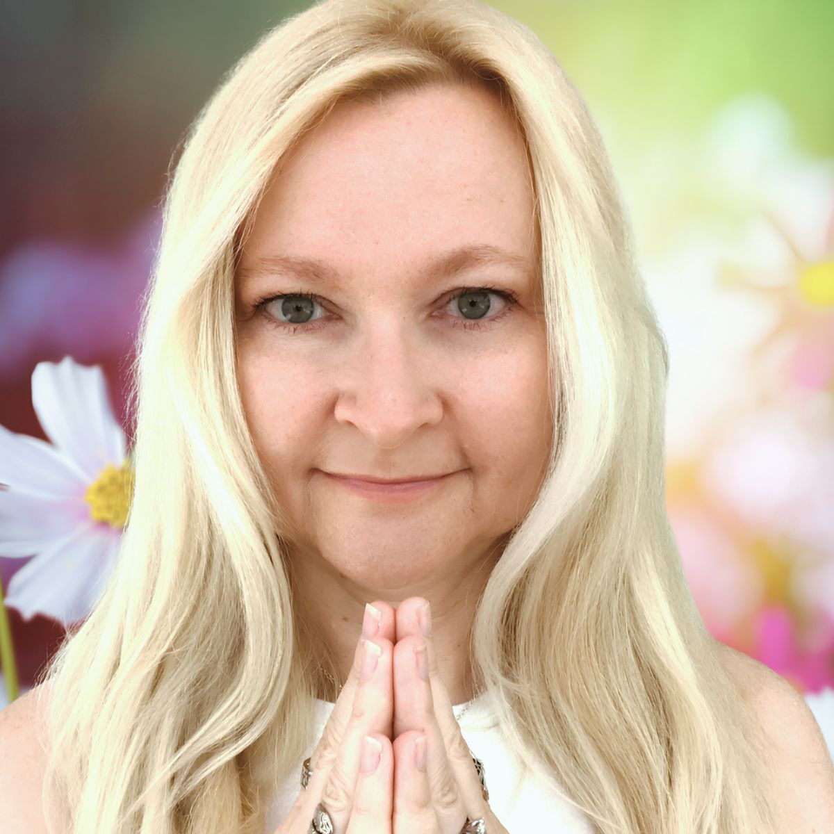 Dorian Lynn, RN and Reiki Master, founder of Mystic Medicine Boutique, in prayer hands pose with soft floral background